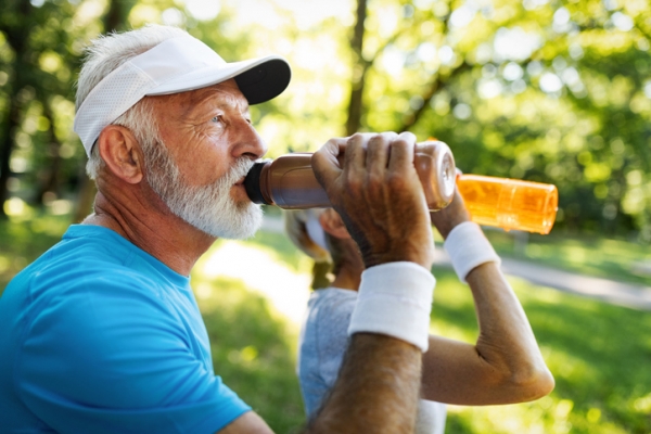 An old man is drinking high-protein drinks during work-out